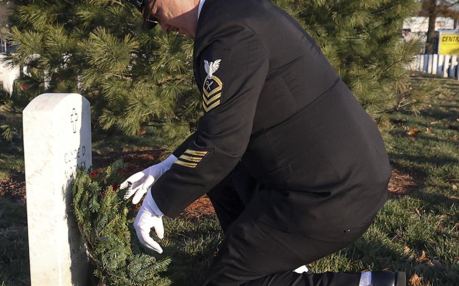 Chief Petty Officer Conor Ford places a wreath during Wreaths Across America at Arlington National Cemetery, Dec. 14, 2024.