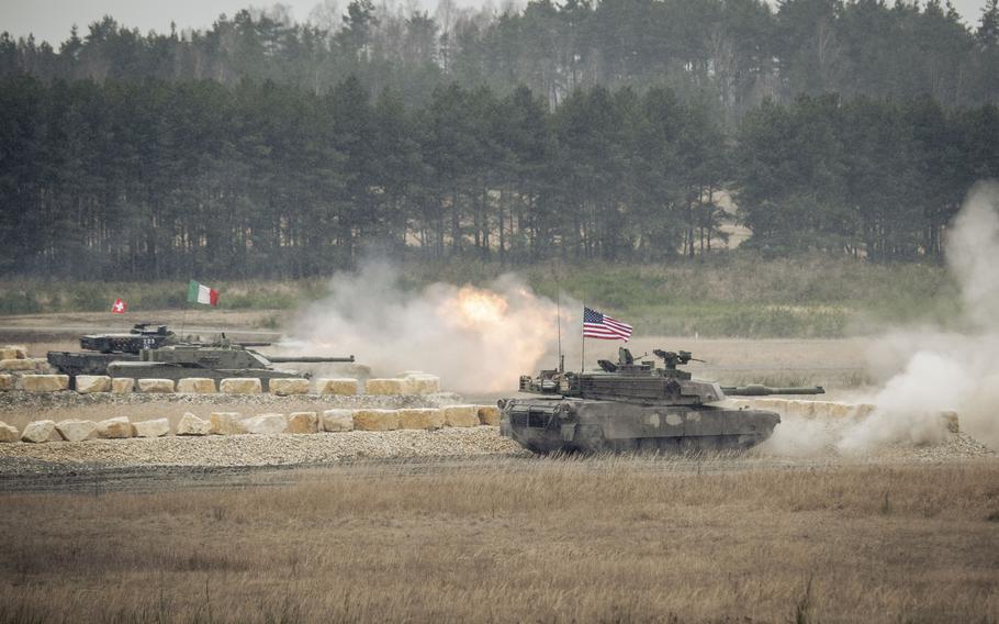 Tanks from five countries line up to fire during a competition. 