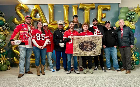 George Kittle with his family, friends and Col. Robert Barnhart smile for a group photo.