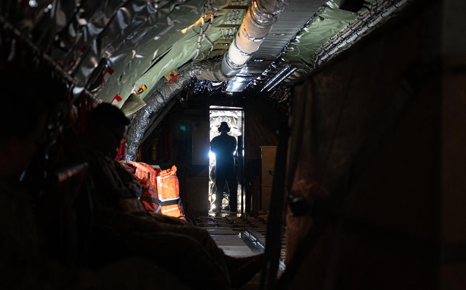 An airman stands in the cockpit of an aircraft