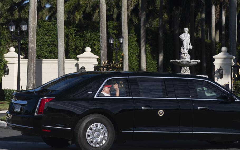 Donald Trump looks out the windo of the limo and waves.