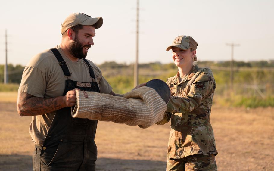 Trainers helps Air Force 2nd Lt. Madison Marsh put on a bite sleeve