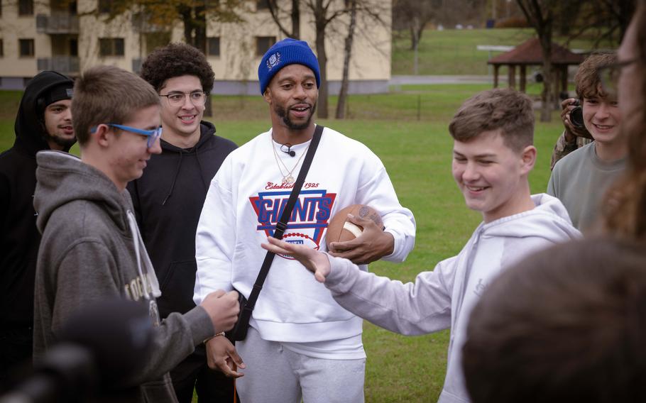 Victor Cruz, a former wide receiver for the New York Giants, talks to Vilseck High School students before playing tag football with them at Rose Barracks, Germany, Nov. 7, 2024.