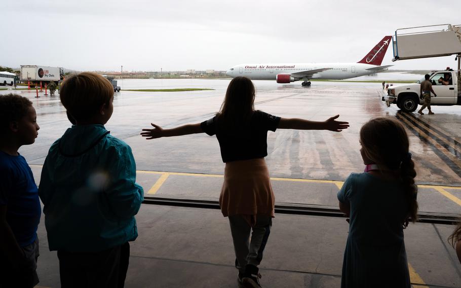 Airmen’s children watch as the Patriot Express touches down in front of the temporary passenger terminal at Andersen Air Force Base, Guam, on May 30, 2023. The regular terminal was significantly damaged by Typhoon Mawar.