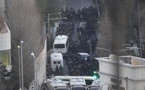 A crowd of law enforcement officials makes its way down a street.