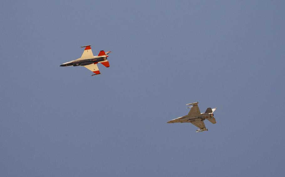 An AI-enabled Air Force F-16 fighter jet, left, flies next to an adversary F-16, as both aircraft race within 1,000 feet of each other, trying to force their opponent into vulnerable positions, on Thursday, May 2, 2024, above Edwards Air Force Base, Calif. The flight is serving as a public statement of confidence in the future role of AI in air combat. The military is planning to use the technology to operate an unmanned fleet of 1,000 aircraft. 