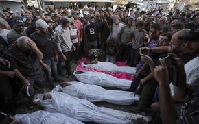 Mourners gather around the bodies of Palestinian men who were killed in an Israeli airstrike in Deir al-Balah, Gaza, Sunday, Oct. 6, 2024. (AP Photo/Abdel Kareem Hana)