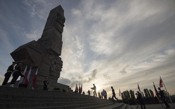 People lay a wreath at the monument to the 1939 heroic defense of the Westerplatte peninsula outpost during solemn observances of the 85th anniversary of the outbreak of World War II, at Westerplatte, on the Baltic Sea, Poland, on Sunday, Sept. 1, 2024. Attacked by a German Nazi warship in the small hours on Sept. 1, 1939, the Westerplatte military outpost was supposed to hold out for 24 hours, but its soldiers put up resistance to the Germans for seven days. (AP Photo/Wojciech Strozyk)