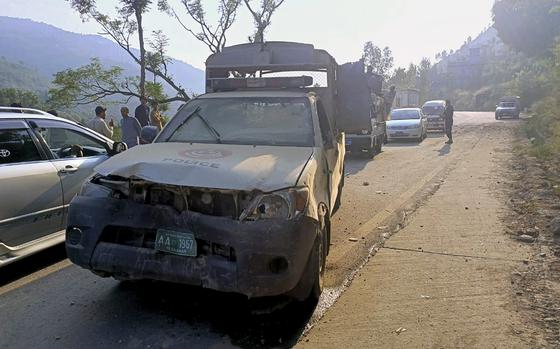 Vehicles drive past a damaged police vehicle, foreground, which was escorting a convoy of foreign diplomats, at the site of a fatal bomb explosion on a road near Malam Jabba, a tourist area in Pakistan's Khyber Pakhtunkhwa province, Sunday, Sept. 22, 2024. (AP Photo/Sherin Zada)