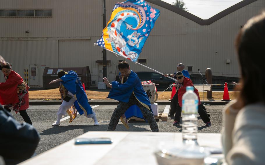 Dancers, one waving a large colorful flag, put on a performance.