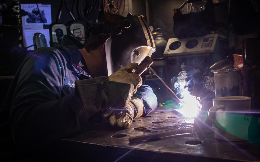 Sailor welding on a ship.