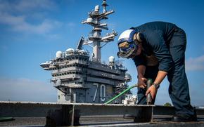 Seaman Keenan Williams, an aviation boatswain’s mate airman, does preventive maintenance on the flight deck of USS Carl Vinson Aug. 21, 2024. A government watchdog agency found that the Navy's staffing and training are inadequate for routine maintenance and repairs on ships at sea.