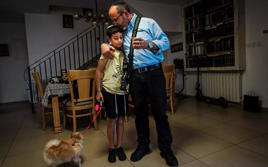 Tzvika Mor embraces son RoeOe, 12, before heading out for the day.