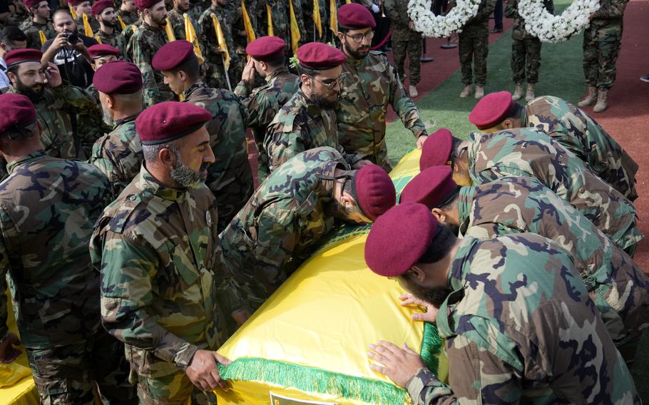 Hezbollah members mourn over the coffins of two of their comrades