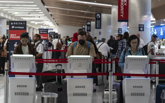 Travelers use kiosks to check in for flights in the Delta Airlines ticketing area at the Los Angeles International Airport in Los Angeles, Friday, Aug. 30, 2024. (AP Photo/Jae C. Hong)