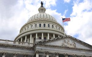 The dome of the U.S. Capitol building, seen from below, with a U.S. flag flying over it.