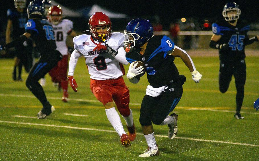 Ramstein's Shaun Young runs with the ball while Kaiserslautern defender Sevastion Quiles chases during a Sept. 13, 2024, game at Ramstein High School on Ramstein Air Base, Germany.