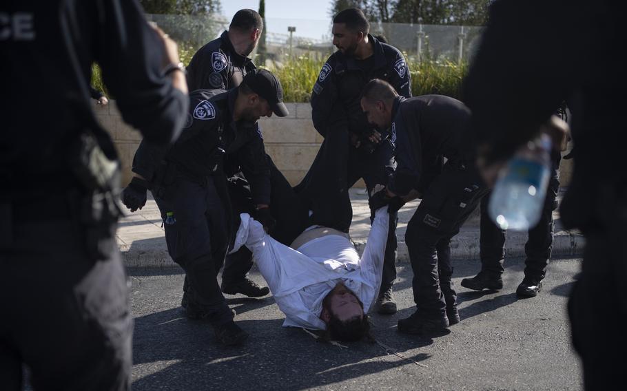 Israeli police officers remove an ultra-Orthodox Jewish man from the street during a protest in Jerusalem against army recruitment on June 2, 2024.