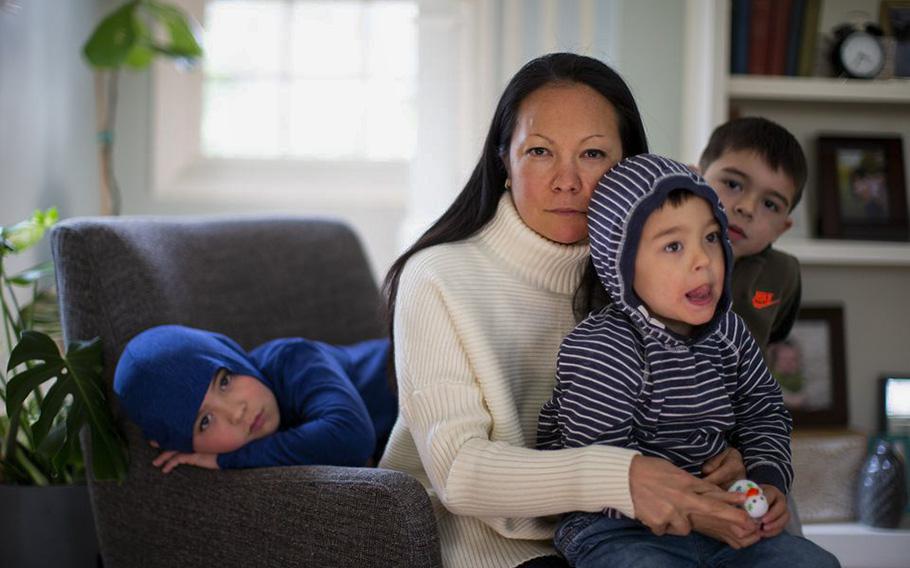 Sarah Truax, 43, sits in her home in Portland on March 29, 2023 with her children Evan, 9, left, Brian, 6, right and Owen, 3. Truax was punched by a stranger in a park earlier in the month. While she called out for help, bystanders did not come to her aid.