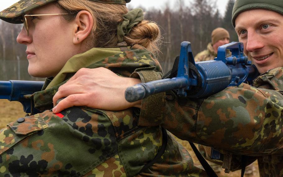 A German soldier puts his left hand on the left shoulder of another soldier during an exercise at the Grafenwoehr Training Area, Germany.