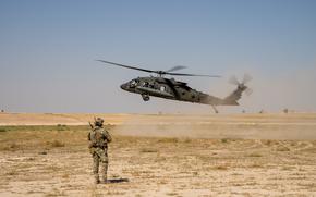 U.S. Air Force Airman, a combat control technician assigned to the Combined Special Operations Joint Task Force - Levant, watches a UH-60 Blackhawk land after clearing the landing zone in support of Combined Joint Task Force - Operation Inherent Resolve in Northeast Syria. (U.S. Army photo by Staff Sgt. Emma Scearce)