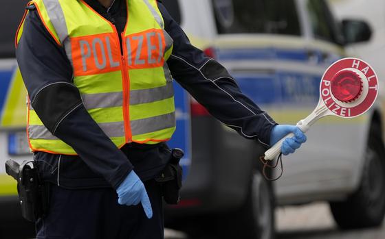 FILE - A German federal police officer stops cars and trucks at a border crossing point between Germany and Czech Republic in Furth am Wald, Germany, Tuesday, Oct. 10, 2023. (AP Photo/Matthias Schrader, File)