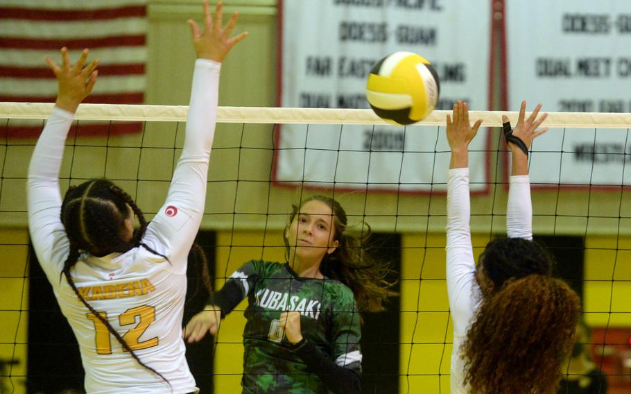 Kubasaki's Alice Baron spikes through the double block of Kadena's Nalana Williams and Malea Williams during Tuesday's Okinawa girls volleyball regular-season finale. The Dragons won all 12 regular-season matches without dropping a set against the Panthers.