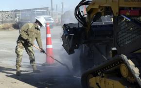 Air Force Staff Sgt. Lukasz Krawcyzk uses a shovel to remove excess debris from the path of a wheel saw during a runway repair exercise at Yokota Air Base, Japan, Feb. 6, 2025.