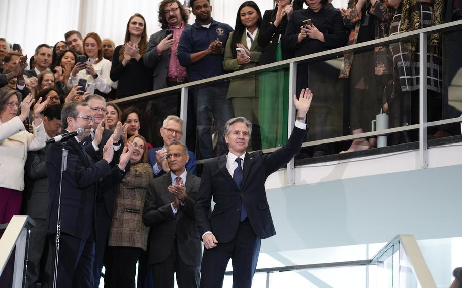 A crowd gathers at the State Department and applauds Antony Blinken.