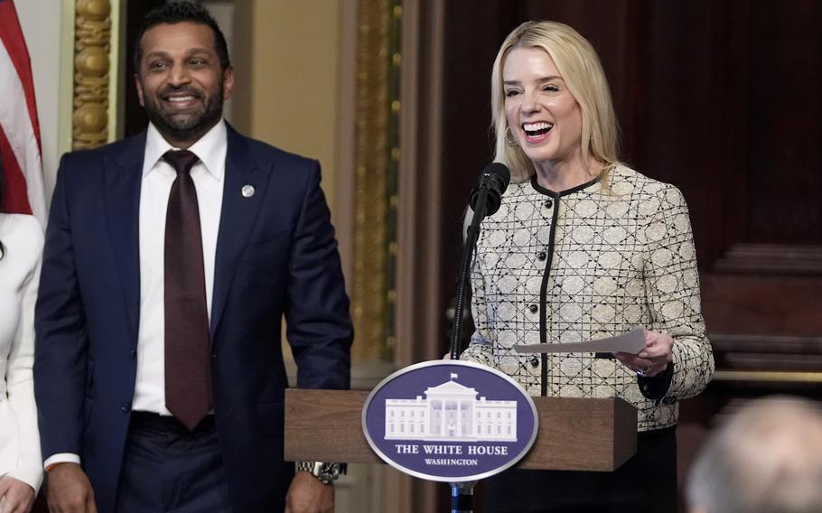 Pam Bondi, with the White House seal on the lectern in front of her, and Kash Patel smile during a ceremony.