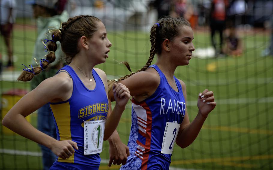 Ramstein’s Cecelia Thompson pushes past Sigonella’s Isabella Lyon during the girls 3,200 meter varsity run at the 2024 DODEA European Championships at Kaiserslautern High School in Kaiserslautern, Germany, on May 24, 2024. The intense race concluded with Lyon narrowly winning with a time of 12:04.69, just 0.32 seconds ahead of Thompson’s 12:05.01.