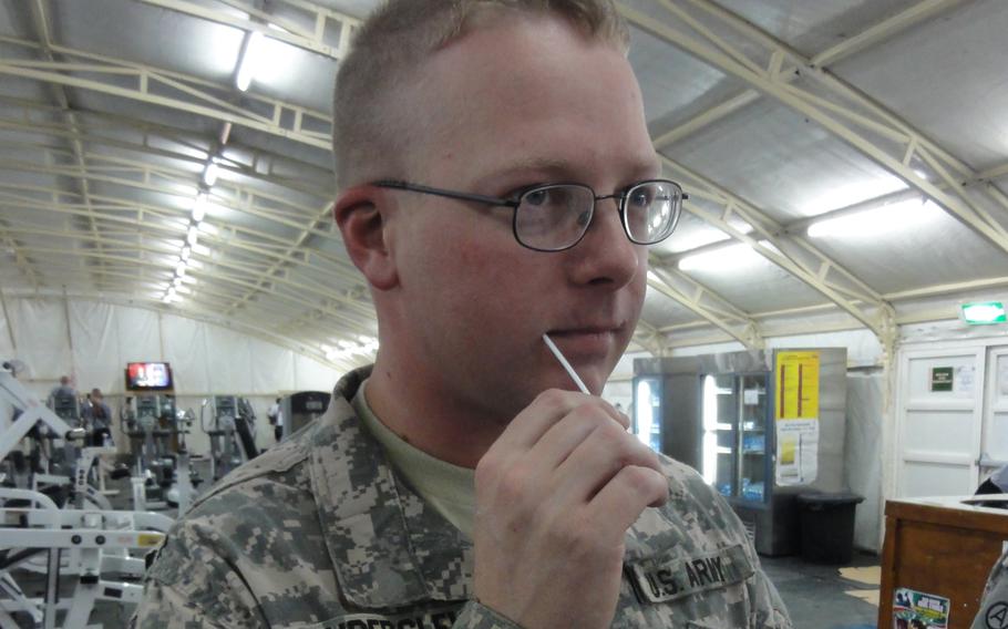 Army Sgt. Chris Vinderslev swabs the inside of his cheek to become registered as a donor in the National Marrow Donor Program Database.