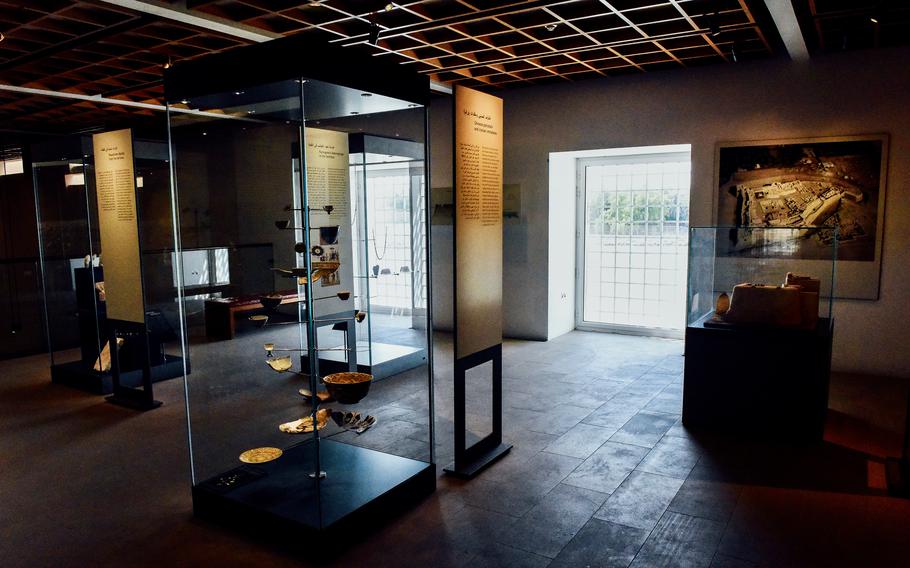 Artifacts are on display in glass cases at the Qal’at al-Bahrain museum. The museum’s architecture combines modern design with the historical significance of the fort. Large windows provide views of the sea and the fort in the distance.