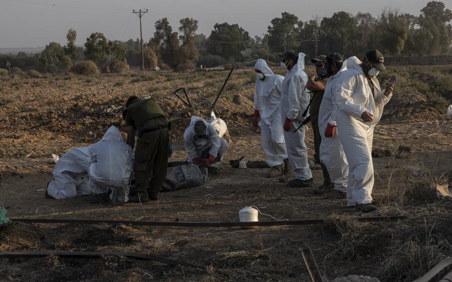 Israeli soldiers recover the bodies of Palestinian fighters at a Kibbutz near the Gaza border on Oct. 14, 2023.