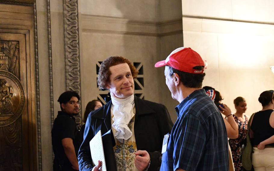 A reenactor portraying Thomas Jefferson speaks with a member of the public inside the National Archives on July 4, 2024.