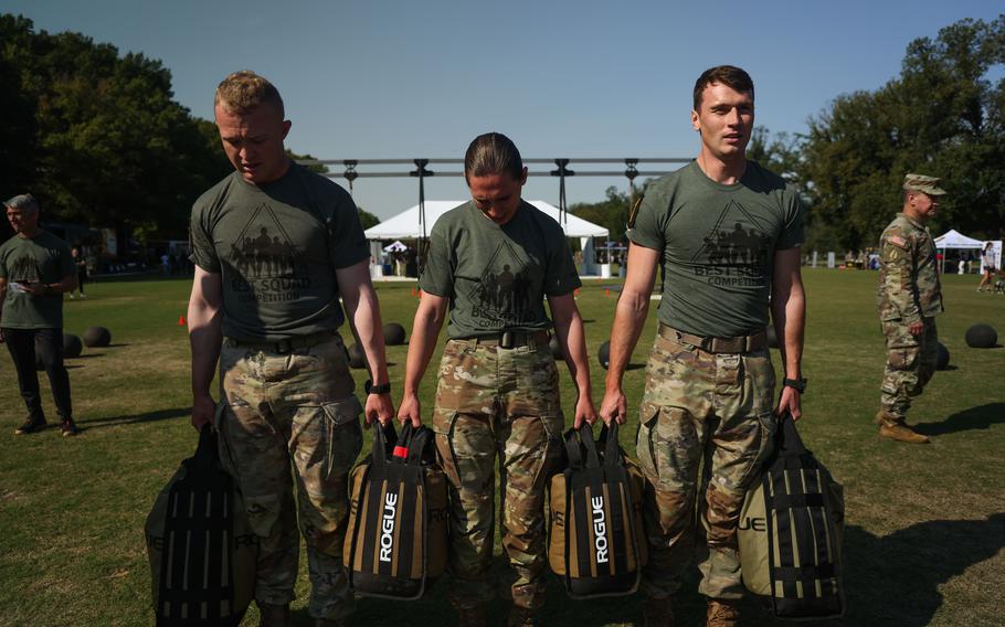 Three U.S. Army soldiers participate in a sandbag carry during the Best Squad Fitness Event in Washington, D.C., Oct. 12, 2024.