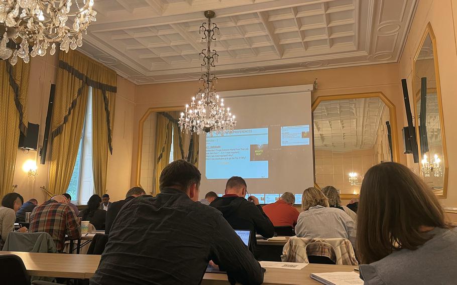 Soldiers participate in seminars in chandelier-lit room in Stuttgart, Germany.