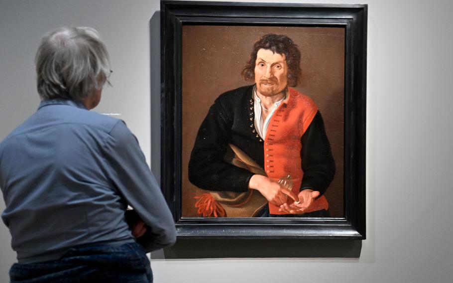 A visitor to “Rembrandt’s Amsterdam. Golden Times?” looks at a portrait of Barend Jansz Bode, also known as Malle Baandje. He was a resident of an Amsterdam orphanage. Usually orphans left the institutions between the ages of 20-25. Because of mental illness, Bode remained his whole life. Who painted the picture and why it was commissioned is unknown.