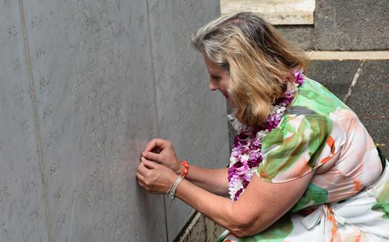 Sharon Deane places a bronze rosette beside the name of her father, Army Lt. Col. William Deane, at the National Memorial Cemetery of the Pacific in Honolulu on Sept. 20, 2024. His missing remains from the Vietnam War were identified in 1999.