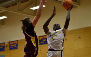 Wiesbaden's Jacob Idowu goes for a shot in the paint while Vilseck's Jeremiah Dorff tries to block him during a Jan. 17, 2025, game at Wiesbaden High School in Wiesbaden, Germany.