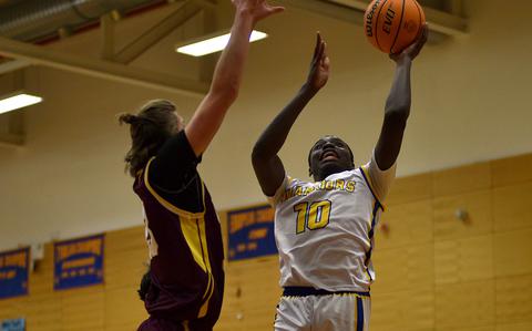 Wiesbaden's Jacob Idowu goes for a shot in the paint while Vilseck's Jeremiah Dorff tries to block him during a Jan. 17, 2025, game at Wiesbaden High School in Wiesbaden, Germany.