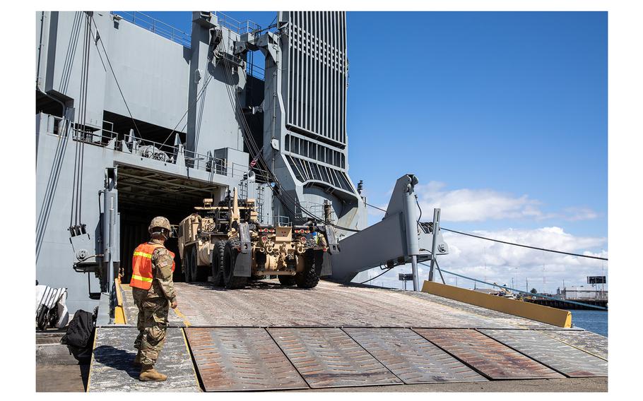 An Army Reserve cargo specialist guides a Heavy Expanded Mobility Tactical Truck as it moves up the gangplank of the MV Cape Orlando (T-AKR2044) during a roll-on/roll-off at the Port of Oakland in Oakland, California, on June 17, 2022. 