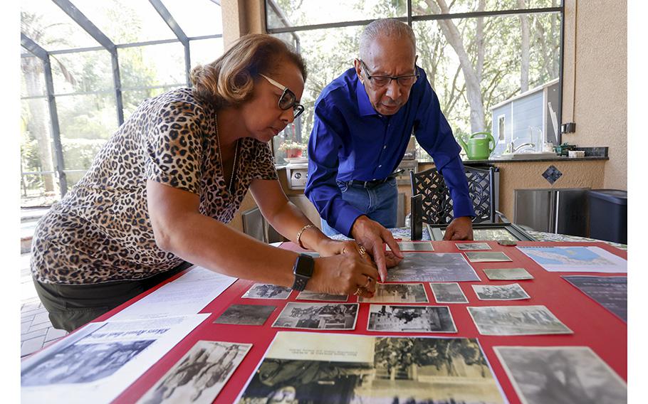 Roy Caldwood, a 100-year-old Buffalo Soldier, and his daughter Diane Royer look at photos he captured in the field while fighting during World War II.