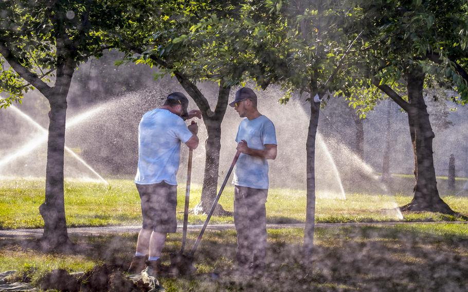 Workmen with the Architect of the Capitol office, perform maintenance on the irrigation system in a park near the Senate, at the Capitol in Washington, Tuesday, June 18, 2024. Extreme heat is expected to break records for tens of millions of people in the United States this week.