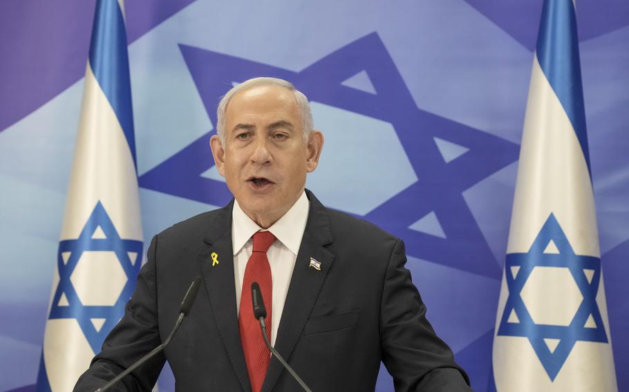 Prime Minister Benjamin Netanyahu, with Israel flags behind him on both sides, speaks during a news conference in Jerusalem.