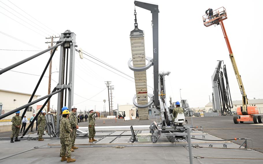 Sailors from the Naval Expeditionary Logistics Support Group and USS Chosin (CG 65) guide a missile canister using the U.S. Navy’s Transferrable Rearming Mechanism as they demonstrate the ability to reload a Vertical Launching System cell on July 11.