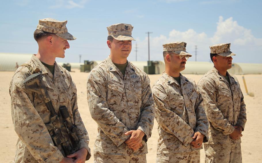 A Marine and three sailors with 1st Battalion, 2nd Marine Regiment, 2nd Marine Division, stand by to be awarded the Navy and Marine Corps Commendation Medal at Twentynine Palms.