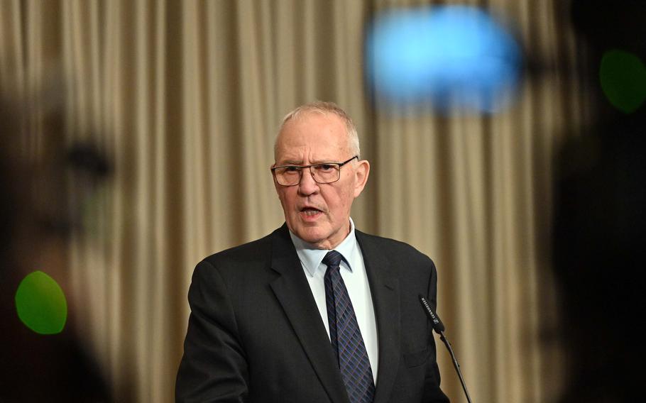 Canadian Defense Minister Bill Blair looks out at reporters as he stands at a lecturn.