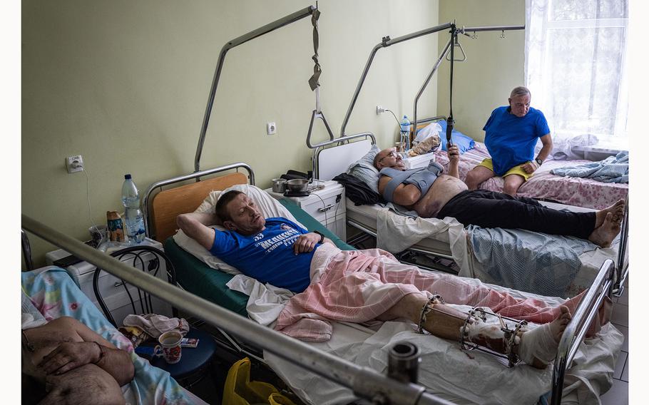 Serhii, 48, a Ukrainian unit commander who was wounded by an FPV drone while fighting in the Belgorod region of Russia, lies in a hospital ward with other injured soldiers in a hospital in northeastern Ukraine. 