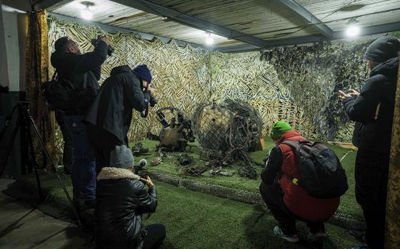 FILE - Journalists at a center for forensic analysis in undisclosed location in Ukraine on Nov. 24, 2024, film fragments of what authorities in Kyiv described as a Russian hypersonic missile that struck a factory in Dnipro, Ukraine, on Nov. 21. (AP Photo/Evgeniy Maloletka, File)